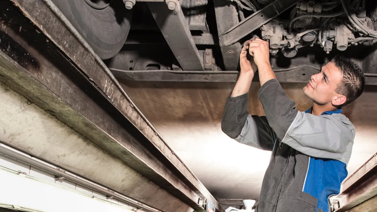 Monteur werkt aan het onderstel van een truck bij IVECO Schouten