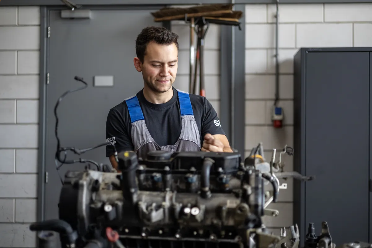 Monteur bekijkt een motorblok in de werkplaats.