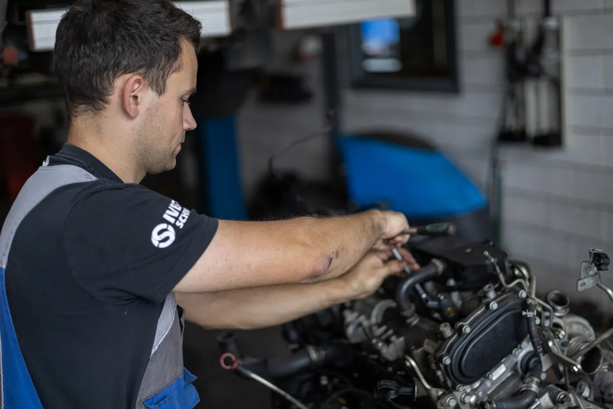 Monteur werkt aan een losgekoppelde motor in de werkplaats.