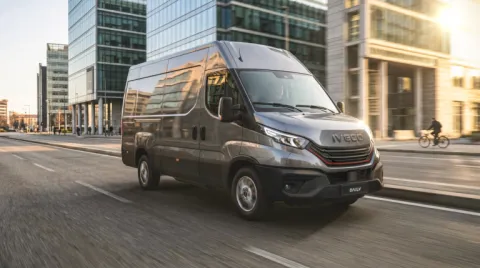 IVECO Daily bestelwagen rijdend langs kantoren in de stad